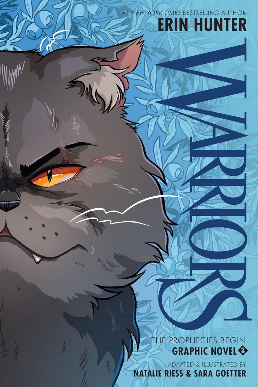 Cover of 'Warriors Graphic Novel: The Prophecies Begin #2' featuring an illustration of a gray cat with intense gaze, set against a blue patterned background.