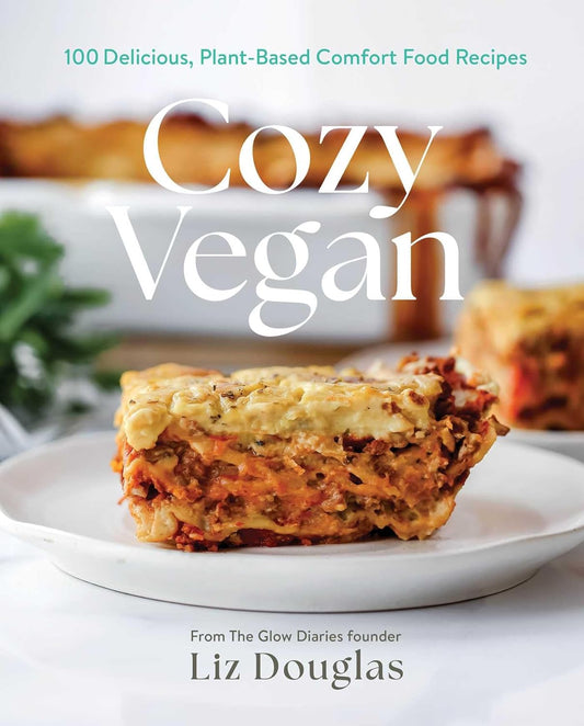 Book cover of 'Cozy Vegan' with a slice of lasagna on a plate.